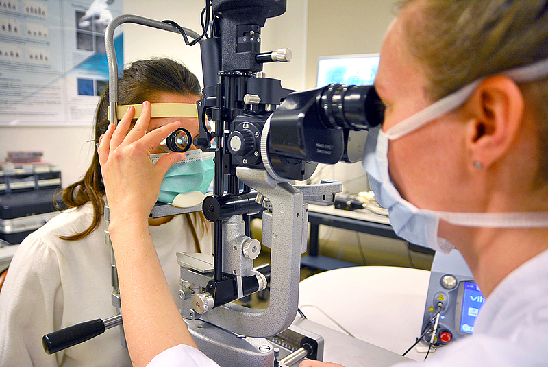 Oberärztin Fr. Dr. Stoll schaut durch ein Untersuchungsgerät in die Augen einer Patientin